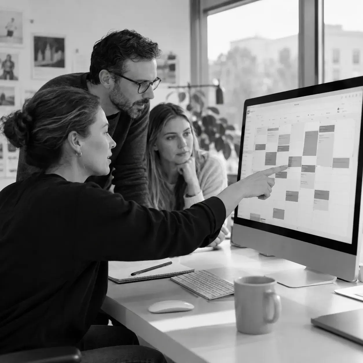 Drei Teammitglieder stimmen einen Projekt- und Veranstaltungskalender am Bildschirm ab